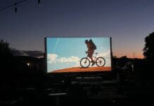 CO150 Film Fest Screens Film Festivities Across Colorado An outdoor movie screen shows a film at sunset for the CO150 Film Festival