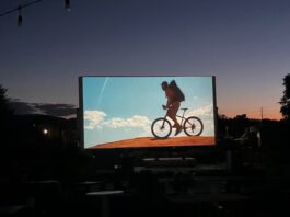 CO150 Film Fest Screens Film Festivities Across Colorado An outdoor movie screen shows a film at sunset for the CO150 Film Festival