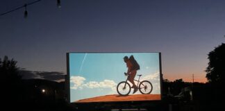 CO150 Film Fest Screens Film Festivities Across Colorado An outdoor movie screen shows a film at sunset for the CO150 Film Festival