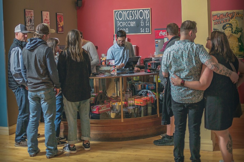 People wait in line at the concession stand before a movie at the Cover 4 Theatre in Fort Morgan, Colorado.