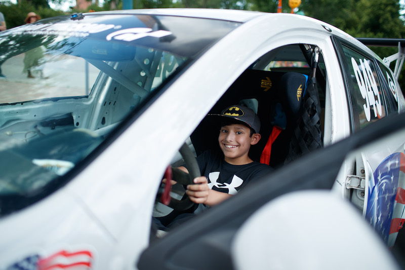 Kid behind the wheel of a race car at the Pikes Peak Hill Climb Fan Fest