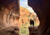 Two hikers silhouetted in the sun at Subway Cave in Sedona, Arizona.