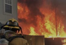 Burn Bans On for Colorado Springs, El Paso County A firefighter battles a wildfire to protect a home