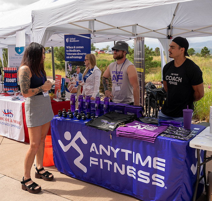 A woman explores the Anytime Fitness booth at the Colorado Springs Health and Fitness Expo.