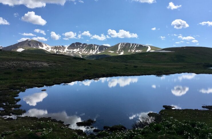 Peaks and clouds reflected in a lake at the summit of Independence Pass, one of the most scenic drives in Colorado.