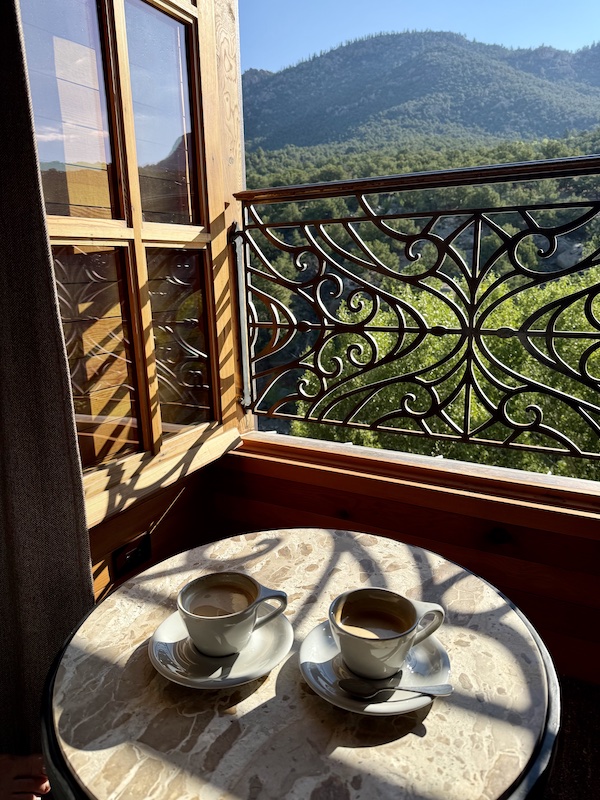 Coffee and mountain view through an open window.