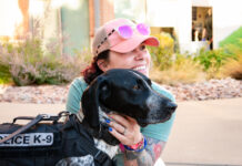 A woman hugs a CSPD K9 dog at Gold Hill Mesa during the launch event for the 2027 CSPD K9 Calendar.