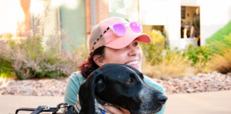 Police Foundation and Gold Hill Mesa Unveil 2027 CSPD K9 Calendar A woman hugs a CSPD K9 dog at Gold Hill Mesa during the launch event for the 2027 CSPD K9 Calendar.