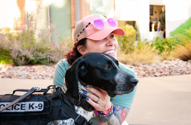A woman hugs a CSPD K9 dog at Gold Hill Mesa during the launch event for the 2027 CSPD K9 Calendar.