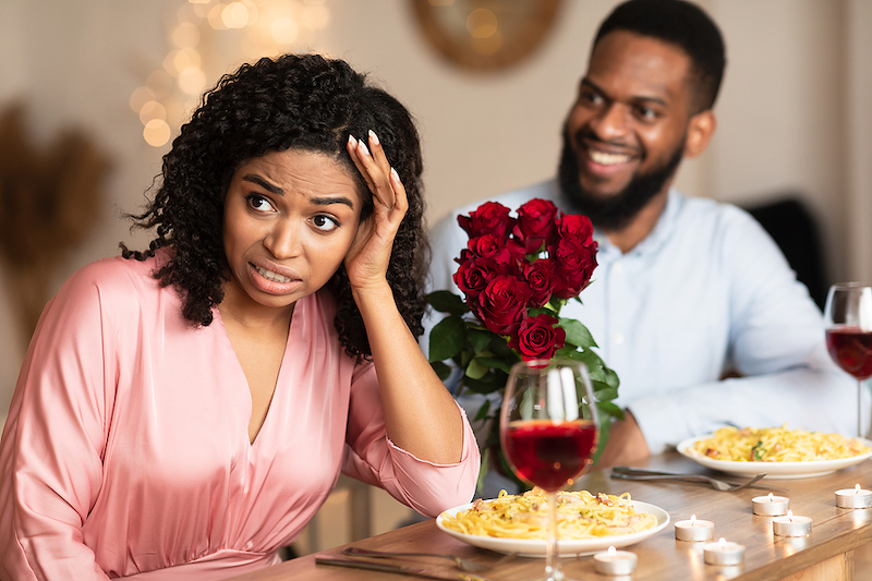 Woman cringes on a bad first date.