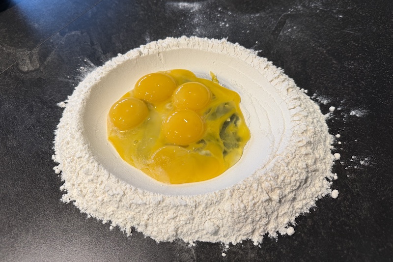 Preparing eggs and flour to make pasta dough from scratch during Roth's cooking class Pasta Fresca with Chef Ricky Biswas.